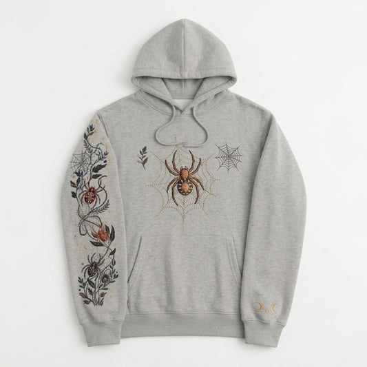 A light heather gray pullover hoodie with a detailed spider-themed graphic print on the right sleeve and a small spider graphic on the left chest, displayed against a solid black background.